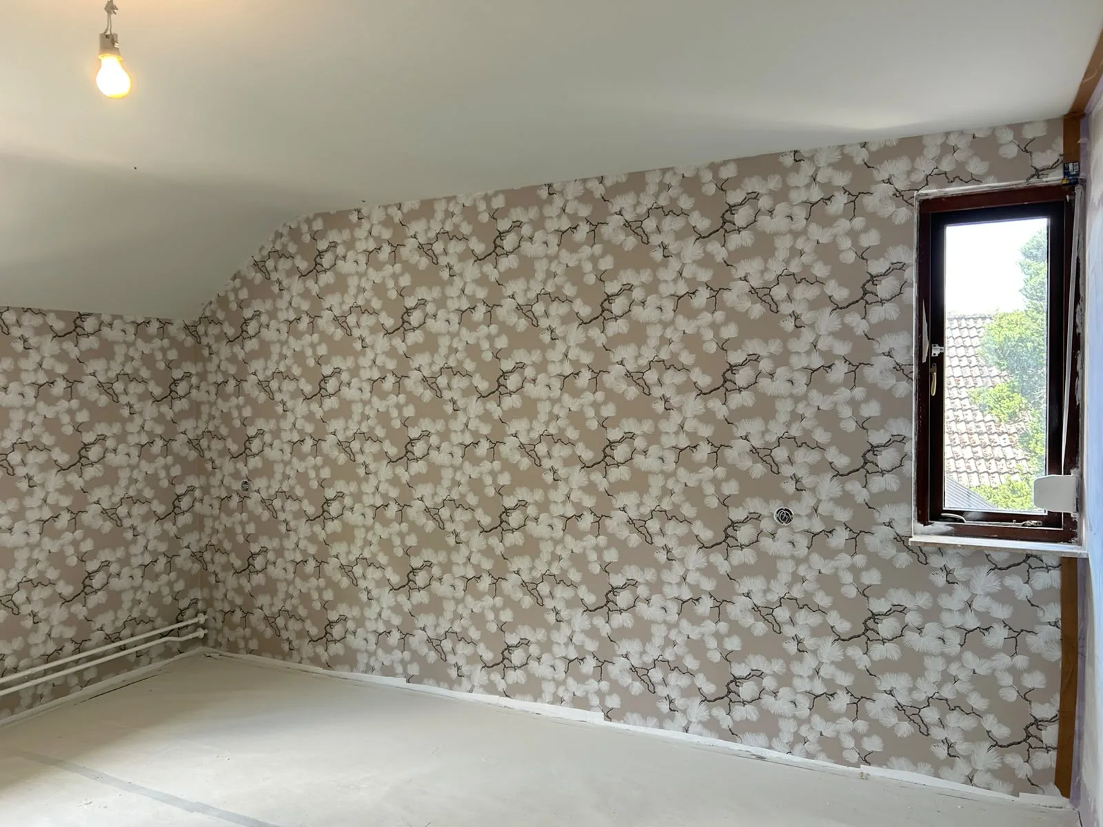 Bloemenbehang in een slaapkamer met schuin dak