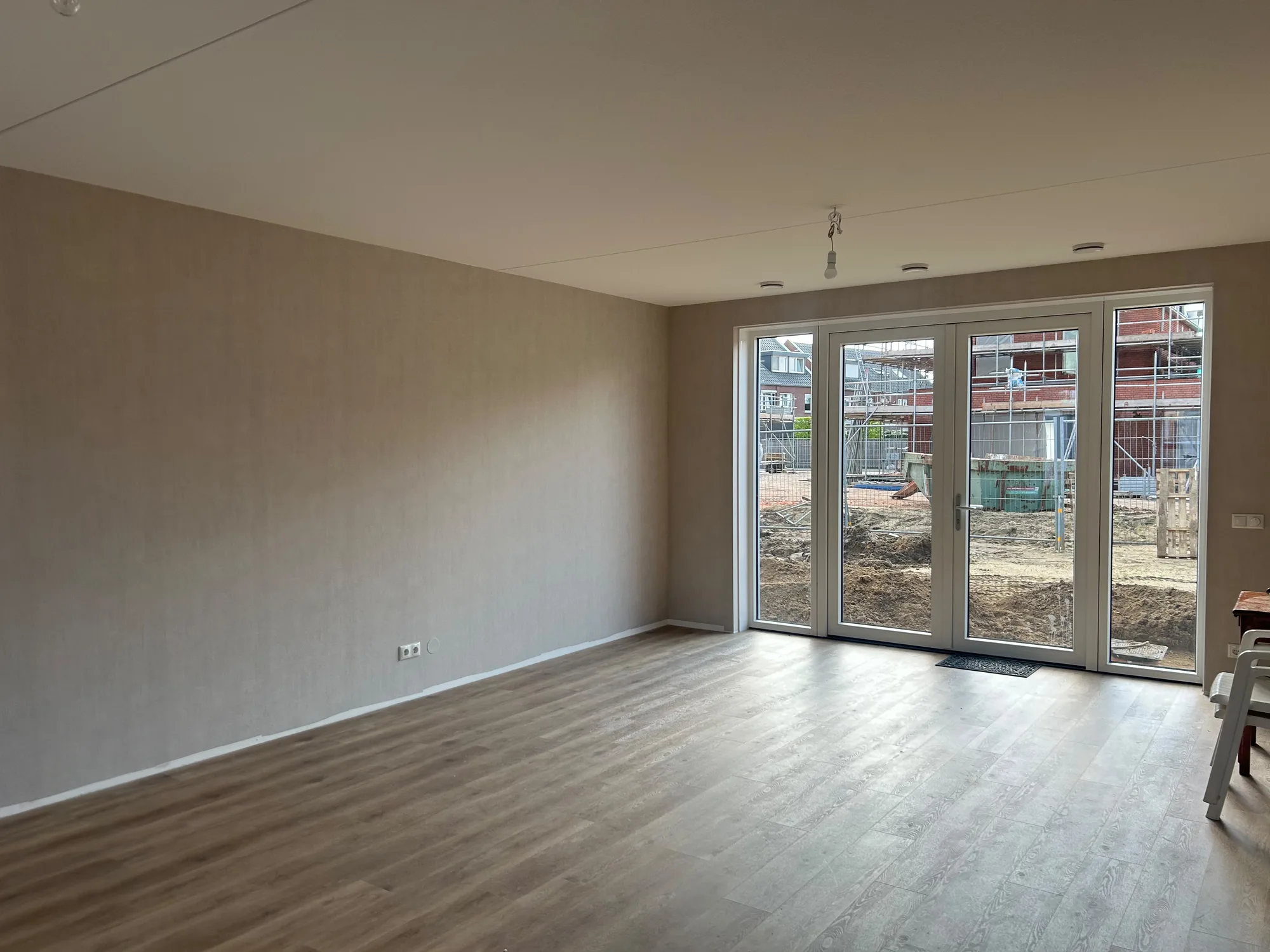 Structuurbehang in een woonkamer met tuindeuren in Noord-Limburg